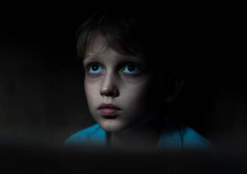 Sad boy sitting in dark room