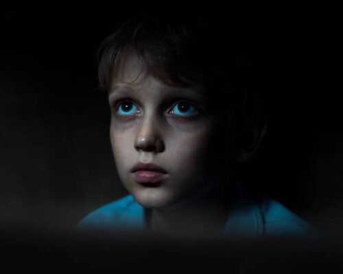 Sad boy sitting in dark room